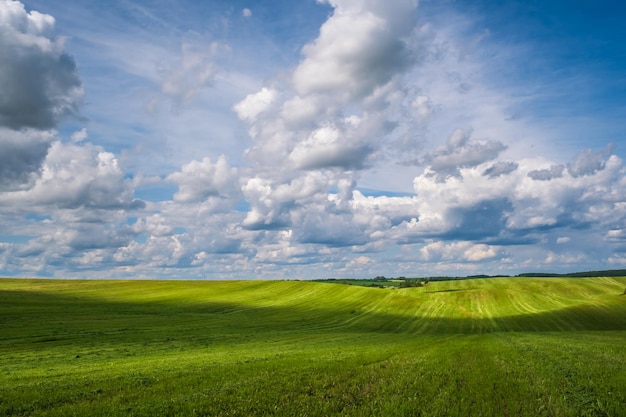 Blue sky background with big white striped clouds in field with gravel road blue sky panorama may use for sky replacement with cloud shadows