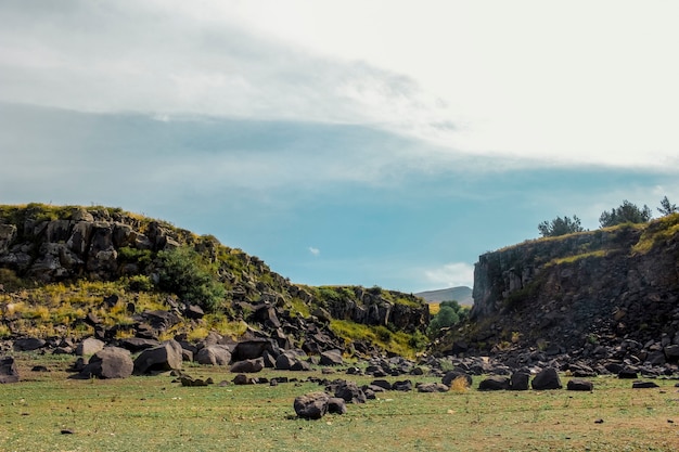 Blue sky and clouds over rocky landscape shot from low angle