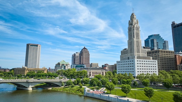 Blue sky day with wispy white clouds over Columbus Ohio downtown with bridge and river