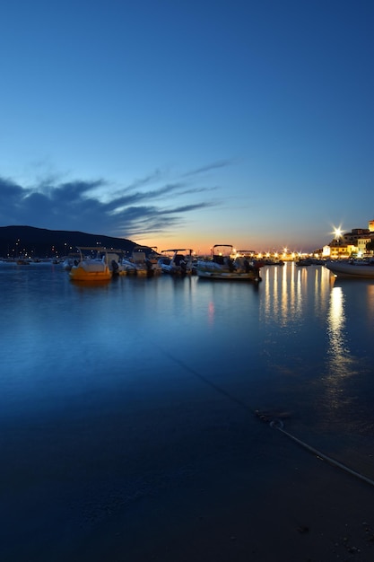 A blue sky is reflected in the water of a harbor.