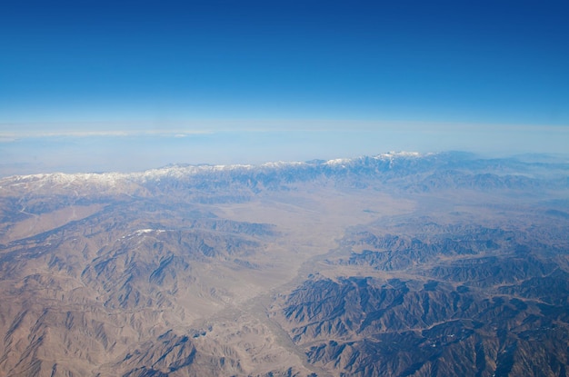 Blue sky and mountains landscape made from flying plane