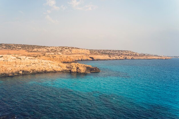 Blue sky. sea rocks and rocks on the beach of Aphrodite. Cyprus. Mediterranean sea