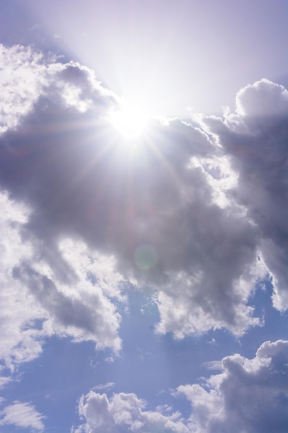 Blue sky and white cumulus clouds clouds obscure the sun sunlight can be seen from behind the clouds