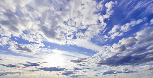 Blue sky with cumulus white clouds in sunshine.