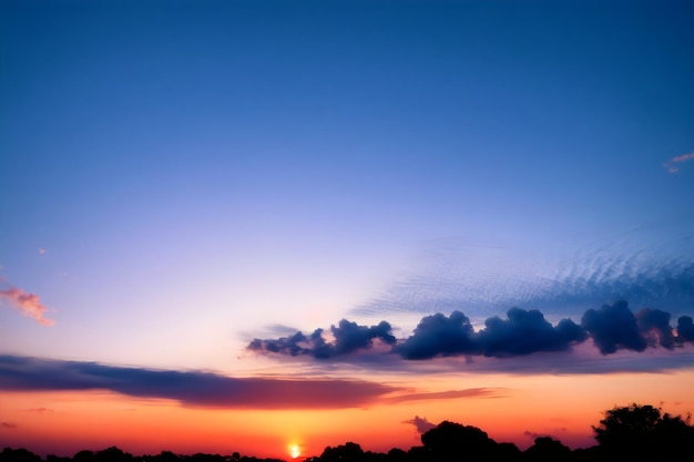 A blue sky with a few clouds and a sunset in the background