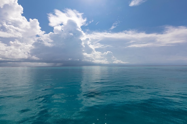 Blue sky with white clouds, natural seascape landscapes over blue sea and reflected on water surface