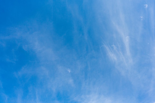 A blue sky with wispy white clouds