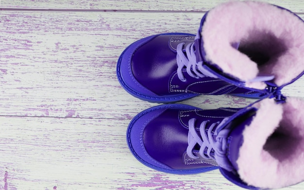 Blue sneakers for a child on a wooden background, children's shoes, a copy of the space.