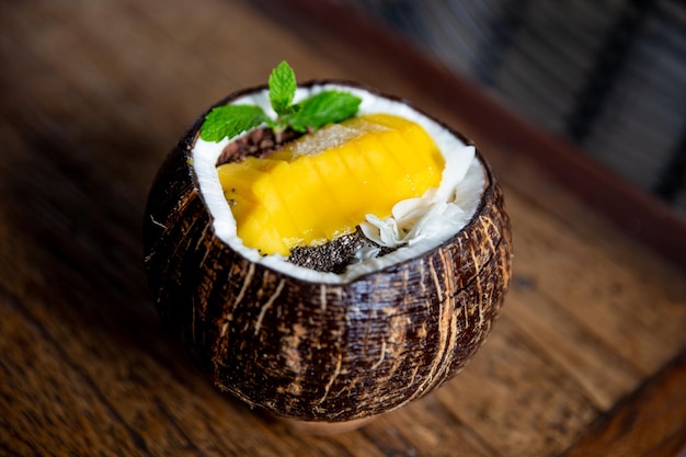 Blue spirrulina smoothie with flakes and chocolate in coconut on rustic background