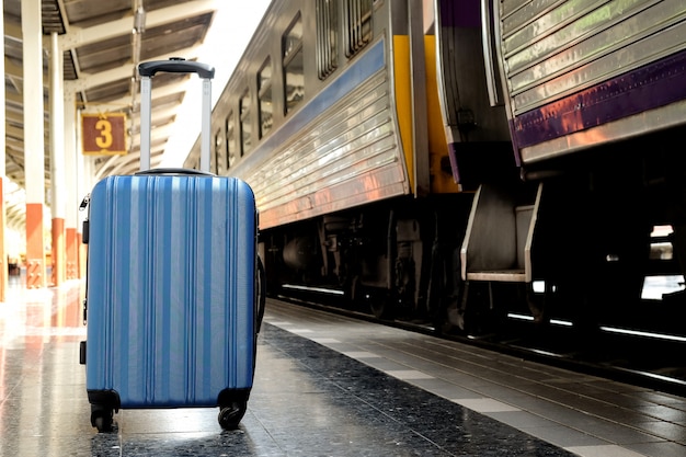 Blue suitcase on the train platform.