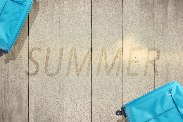 Blue suitcase on wooden floor with the text of summer