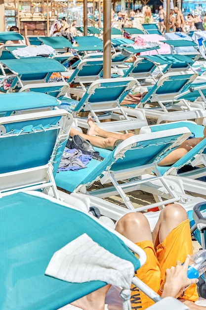 Blue sun loungers put in rows under transparent canopy near swimming pool in touristic water park