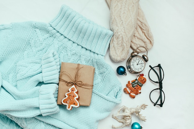 Blue sweater, knitted mittens and Christmas decorations and gift 