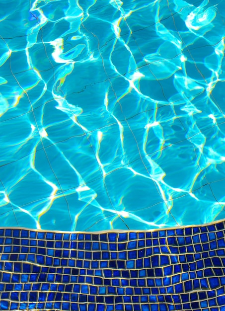 Blue tiles of jacuzzi in the Swimming pool blue water and sunlight reflection effect