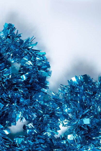 Photo blue tinsel on a white background with copy space for text concept of christmas and new year