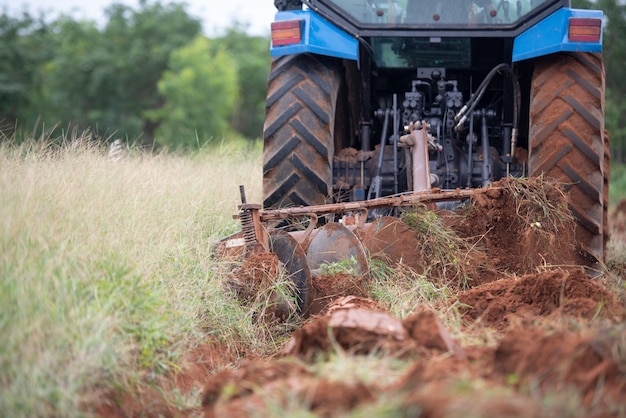 A blue tractor working on farm land 