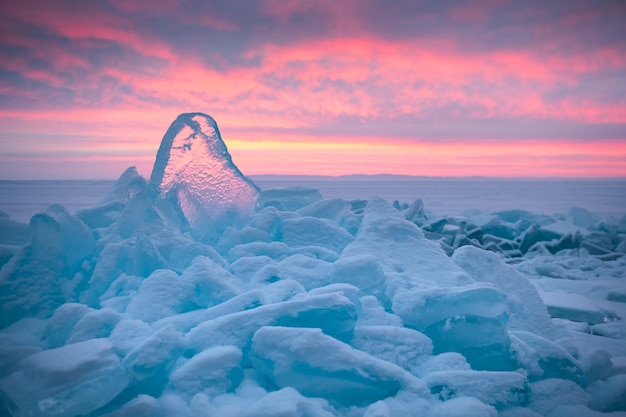 Blue transparent ice on Baikal lake at sunrise Winter landscape