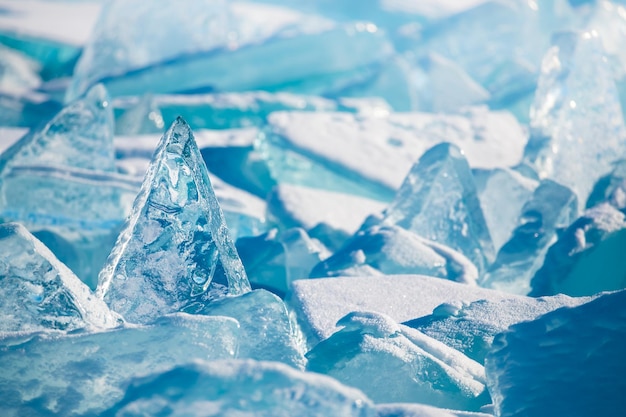 Blue transparent ice with snow on Baikal lake in winter