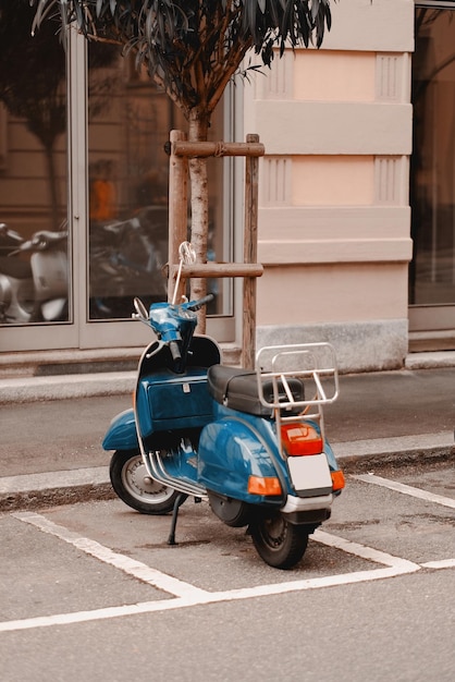 Photo a blue vespa parked in a parking lot