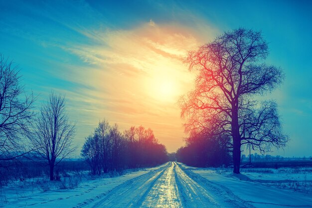 Blue vintage winter snowy rural landscape at sunset