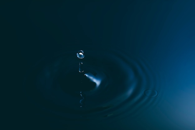 Blue water drop falling down and circles wave.