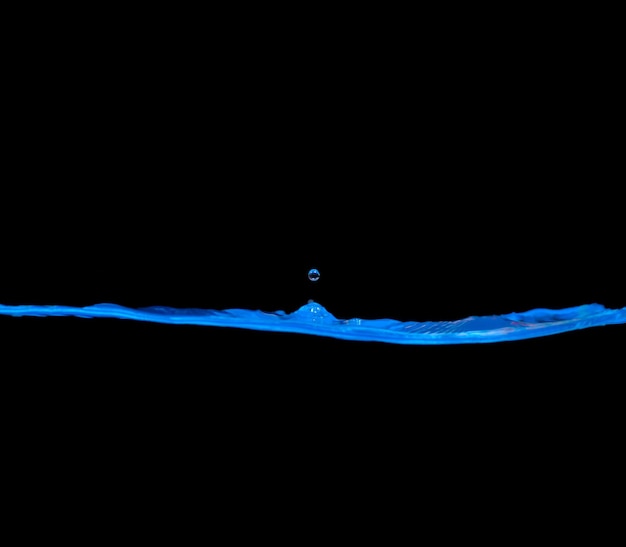 Blue Water waves and air bubbles. black background, copy space above and below.