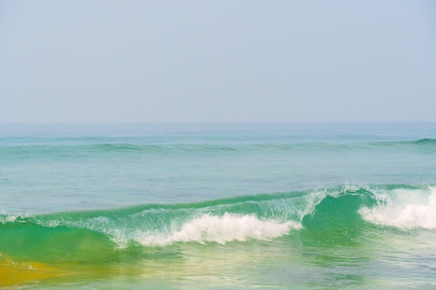 Blue waves of the ocean and yellow sand of the beach.