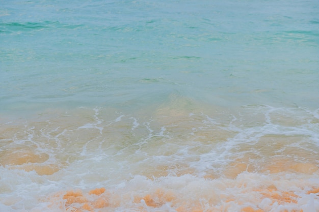 Blue waves of the ocean and yellow sand of the beach.