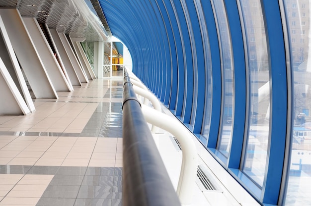 A blue and white tunnel with a blue railing and a blue wall.