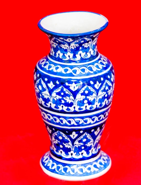 A blue and white vase with a floral pattern on it.