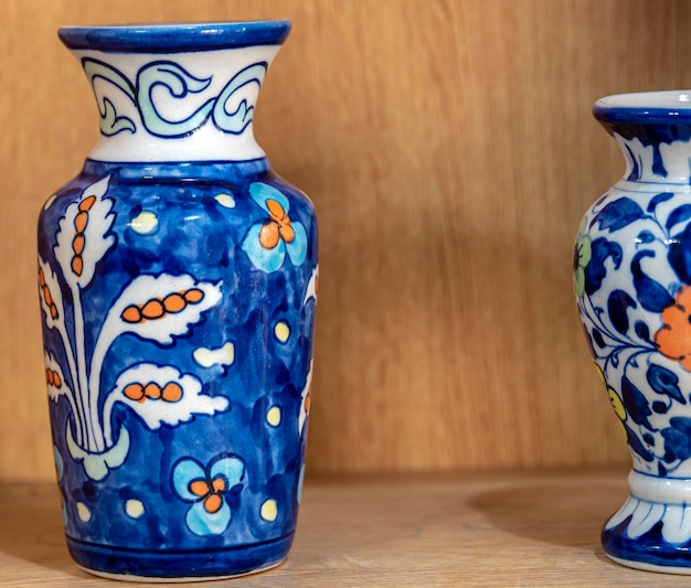 A blue and white vase with a flower design is next to a smaller one.