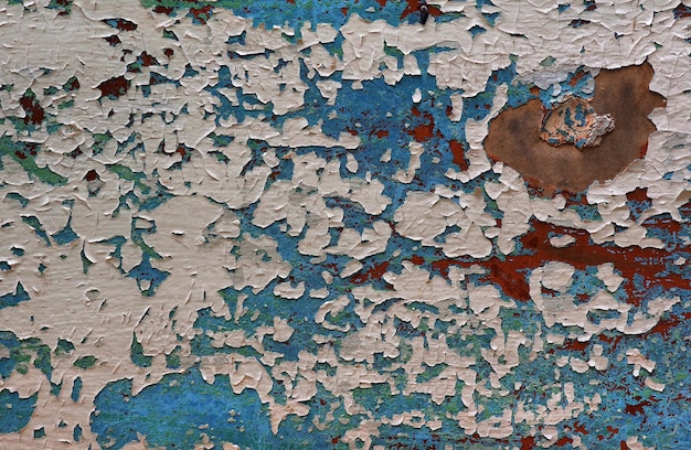 A blue and white wall with a lot of rust on it