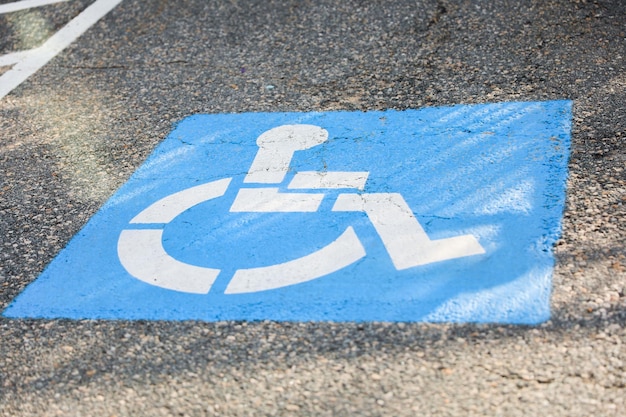 A blue and white wheelchair symbol on a signpost representing accessibility and inclusivity for ind