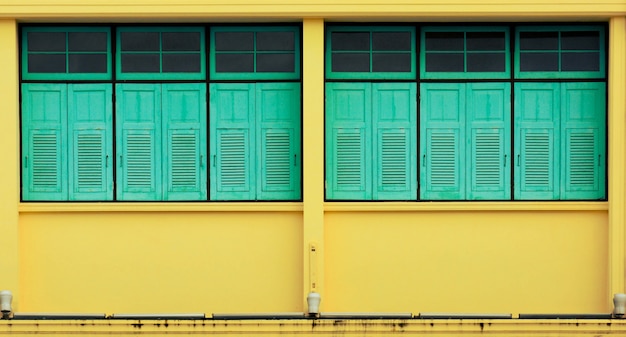 Blue window at antique yellow concrete building