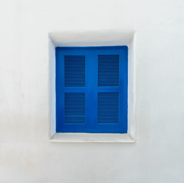 Blue window on mediterranean white wall