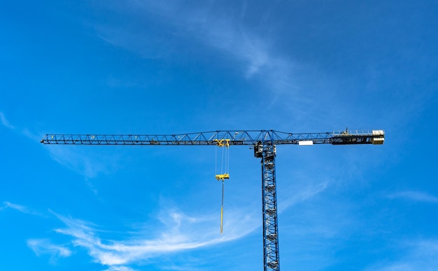 Blue with yellow parts industrial crane on the blue sky