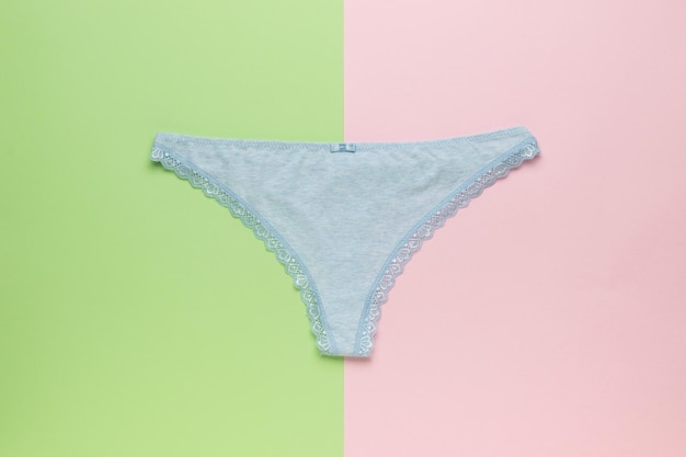 Blue women's panties on a green and pink background Minimal underwear concept