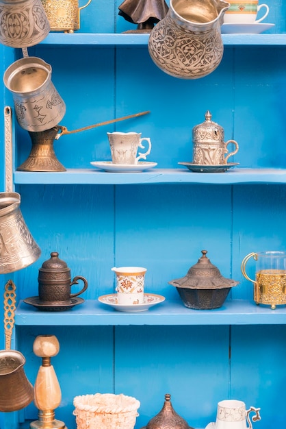 Blue wooden sideboard with antique oriental dishes for tea and coffee