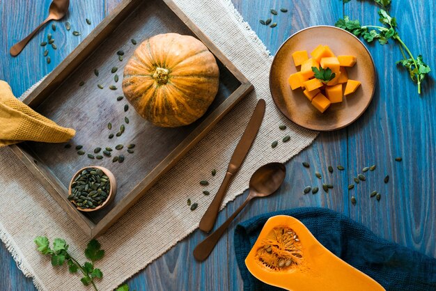 A blue wooden table with orange pumpkins in all forms on top