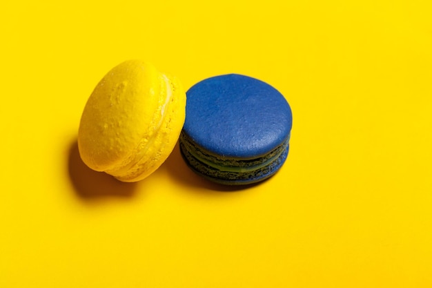 Blue and yellow macaroon on a yellow background