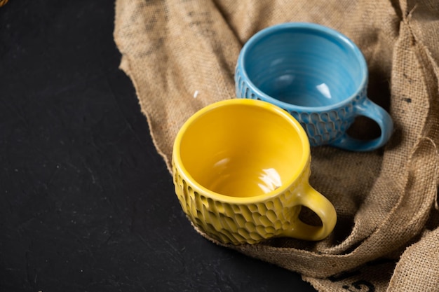 Blue and yellow mugs isolated on a black background