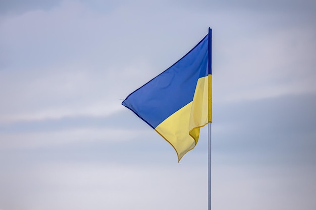 Blue-yellow Ukrainian flag against a cloudy sky. State symbols. Brave Ukraine.