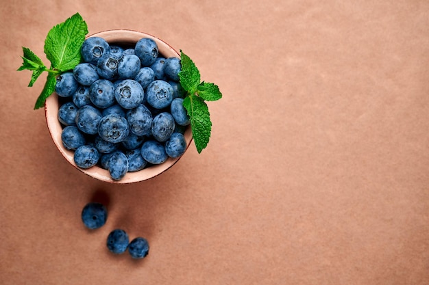 Blueberries in ceramic bowl on kraft paper View from above