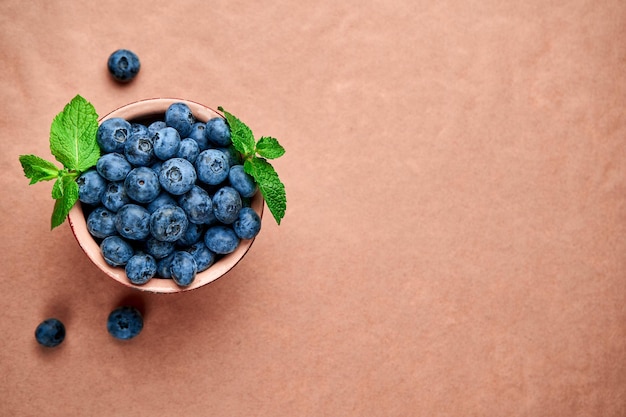 Blueberries in ceramic bowl on kraft paper View from above