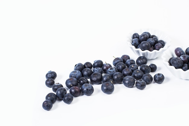 Blueberries in white bowls and on a white background