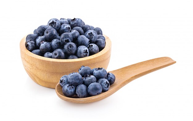 Blueberries in wood bowl and spoon isolated on white