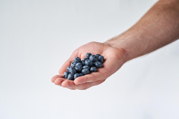 blueberry in hand on white Male hand