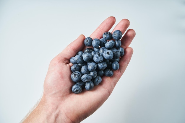 blueberry in hand on white Male hand