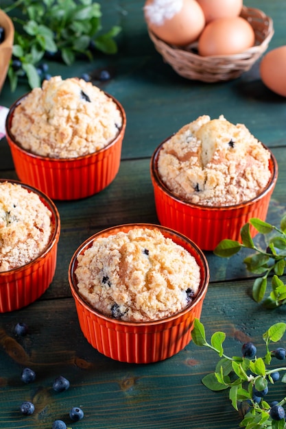 Blueberry muffins with powdered sugar and fresh berries on the green table