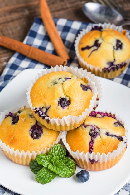 Blueberry muffins with powdered sugar and fresh berries